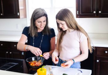 Childhood cancer survivor Anna and mom Krissy making dinner