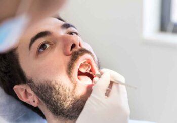 man getting an oral cancer screening at dentist