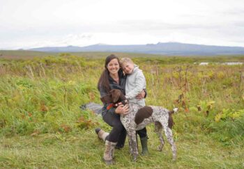 Jenny Foltz, rectal cancer survivor, outside with her son and dog smiling to the camera